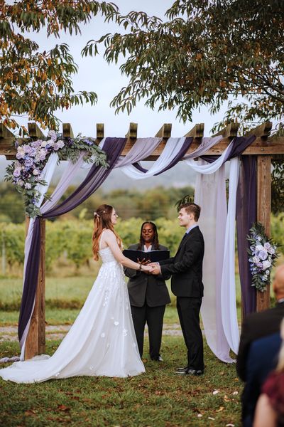 Anastasia arrives at the arch, where Brian and the officiant are waiting.