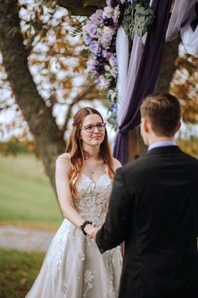 Anastasia smiles up at Brian as the vows begin.