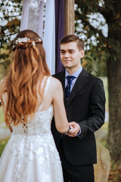 Hand in hand, Anastasia and Brian face each other at the altar.