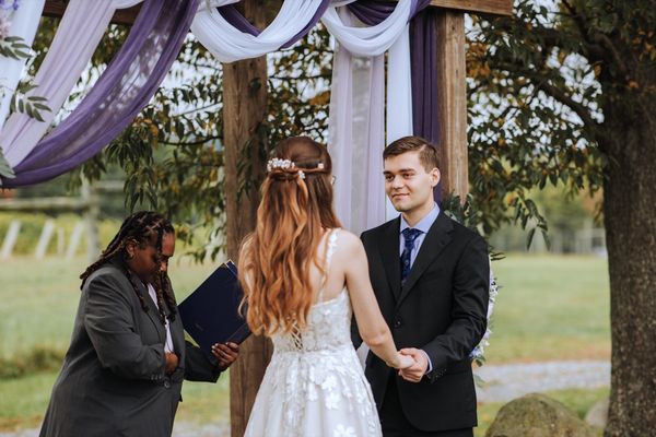 The officiant reads as Anastasia and Brian hold hands.