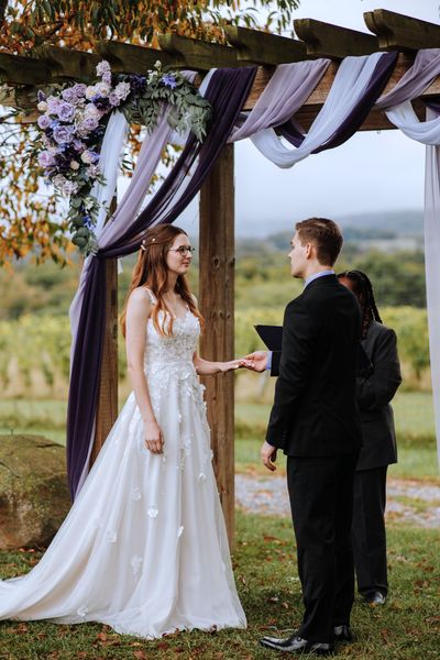Brian slips the ring onto Anastasia's finger.