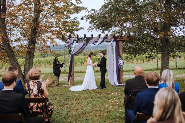 Beyond the rows of guests, the couple stands at the arch for the final words.