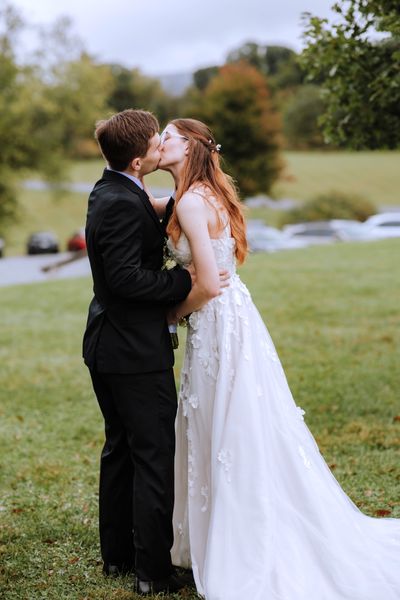 Newly married, the couple shares a kiss on the lawn.