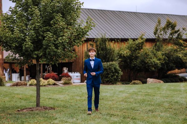 Ivan, Anastasia's brother, waits on the lawn in front of the barn.