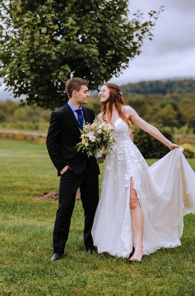 Anastasia sweeps out her skirt as Brian looks on, smiling.