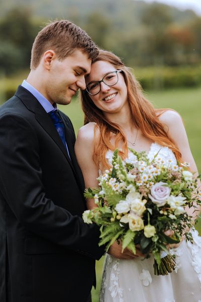 Foreheads close, the newlyweds share a warm smile.