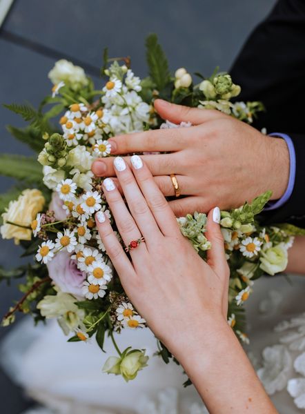 Two new wedding rings rest on the bouquet.