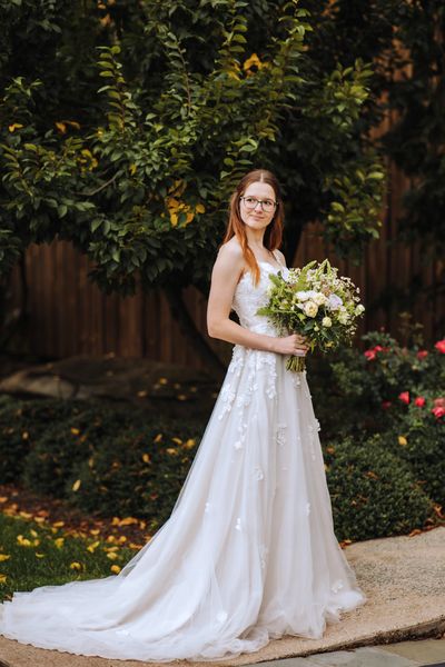 Anastasia in the garden, her gown spilling across the path.