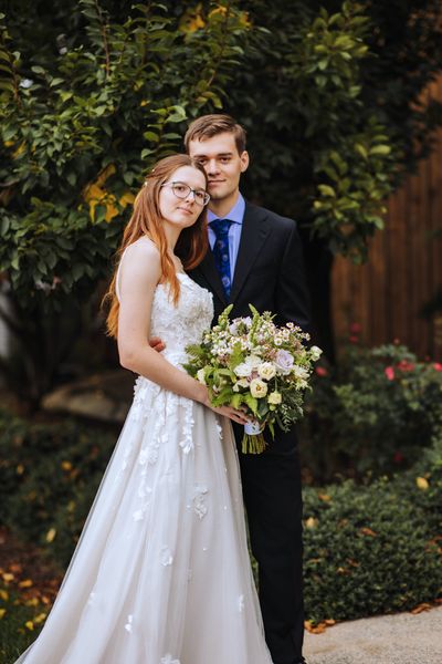 The newlyweds in the garden, Brian just behind Anastasia.