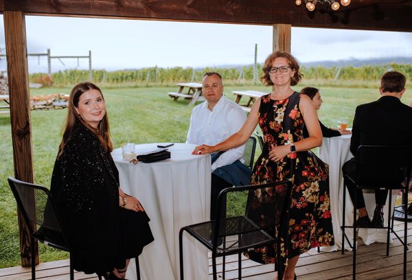 Guests mingle at a cocktail table under the pavilion.