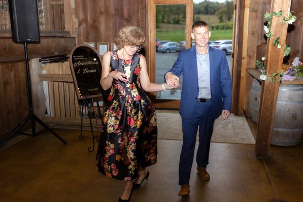 A woman in a floral dress and a man in blue dance their way in.