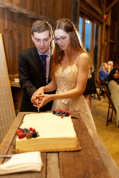 Anastasia and Brian cut the cake together.