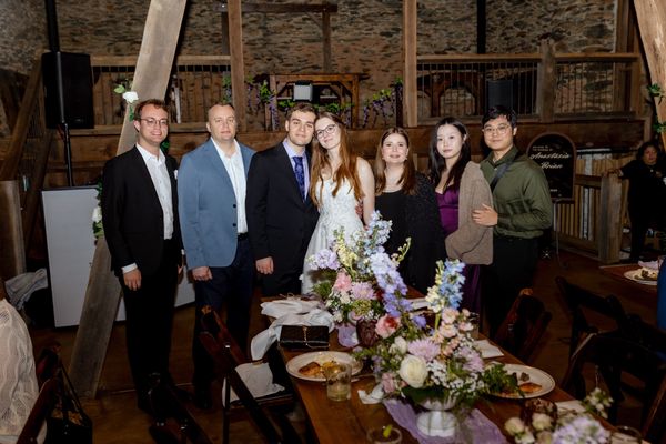 A row of guests lines up behind the table with the bride and groom.