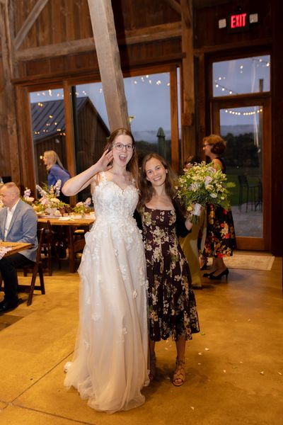 Anastasia and a woman in a floral dress dance together.