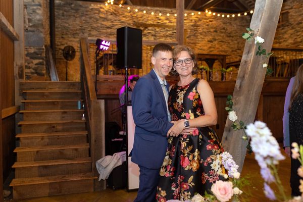A young man and a woman in a floral dress pose on the dance floor.