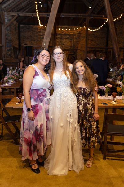 Anastasia with two friends under the twinkling lights.